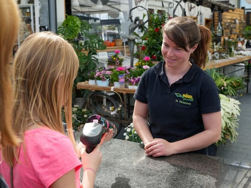 Teilnehmerin vom Girlsday scannt im Gartencenter einen Artikel